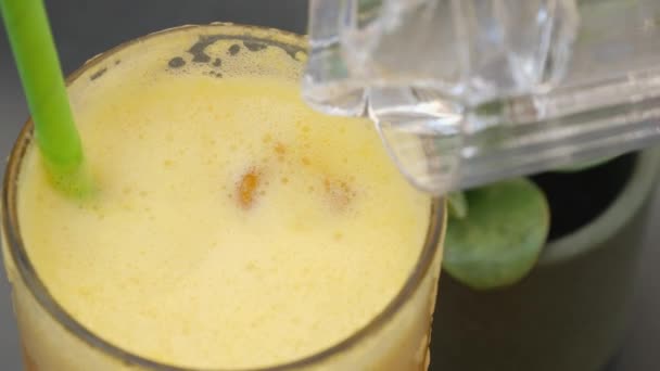 Gyümölcslé jégkockával az üvegkupa belsejében. Friss Orange Drink természetes folyékony vitaminokkal az egészséges étrend érdekében. Jó Modern Menü Hűtött Italral  - Felvétel, videó