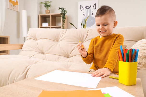Симпатичний маленький хлопчик малює ручками з фетру на столі вдома - Фото, зображення