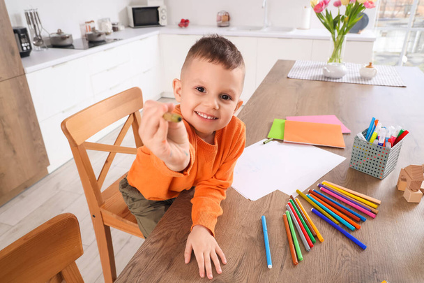 Söpö pieni poika piirustus huopakynät pöydällä keittiössä - Valokuva, kuva