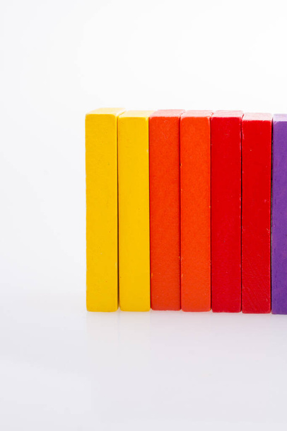 Ruka drží barevné domino na bílém pozadí - Fotografie, Obrázek