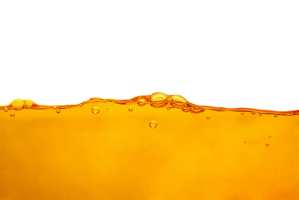 Oranje wateroppervlak met belletjes en waterspatten op witte achtergrond geïsoleerd - Foto, afbeelding