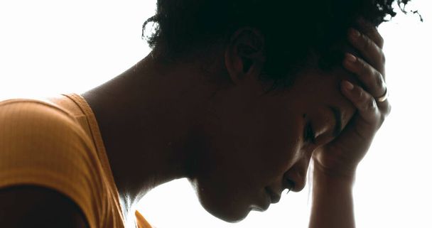 Ehrliche, einsame junge Frau, die mit Depressionen kämpft, Nahaufnahme einer Person, die den Kopf in der Hand hält und emotionale Schmerzen in dramatischer Silhouette erleidet - Foto, Bild