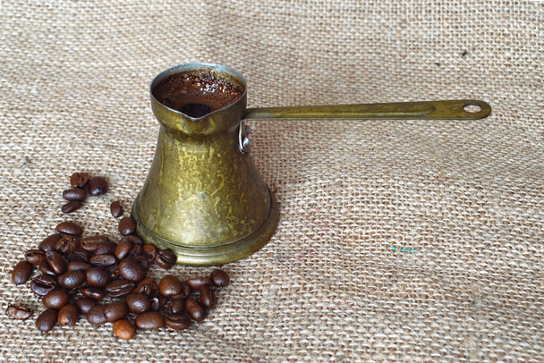 κόκκους καφέ και vintage jezve σε σάκους φόντο - Φωτογραφία, εικόνα