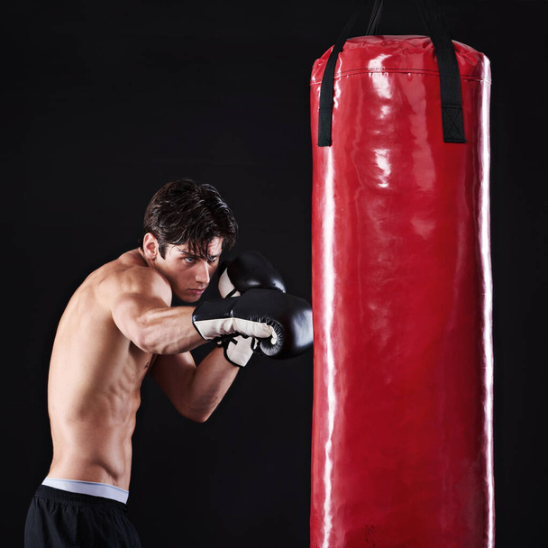 Чоловік, ударна сумка і бойові мистецтва з фітнесом, виклик і боєць з рукавичками і оздоровлення з тренуванням. Боксер, практика і спортсмен з вправами і тренуваннями з витривалістю, здоров'ям або прогресом. - Фото, зображення
