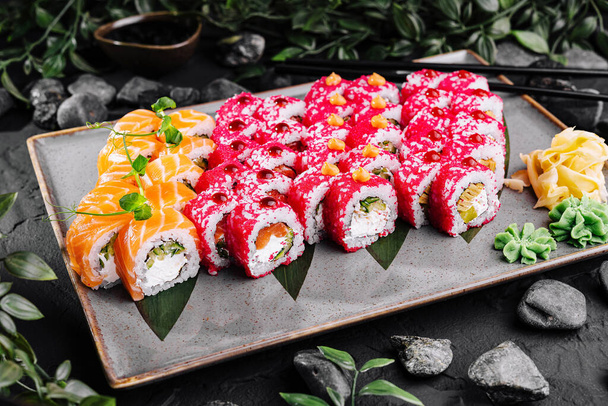 Japanilainen sushi lajike tyylikäs levy mausteet tummalla liuskekivi tausta - Valokuva, kuva