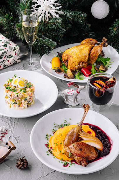 Lezzetli kızarmış ördek, olivier salatası ve sıcak şarap ile birlikte tatil masası. - Fotoğraf, Görsel