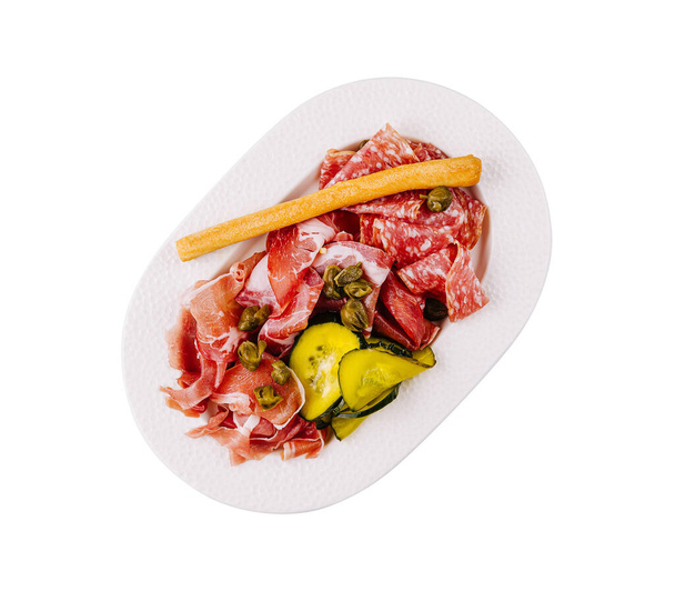 Widok z góry wybór włoskich mięs i ogórków podawane na białym talerzu, izolowane na białym tle - Zdjęcie, obraz