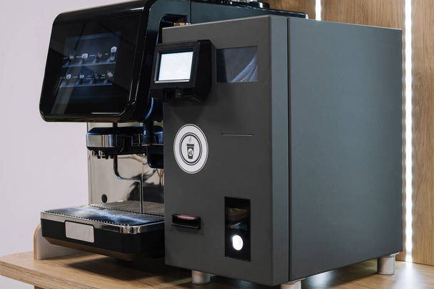 Professionele espressomachine met een strak design, klaar om koffie te zetten op een aanrecht - Foto, afbeelding