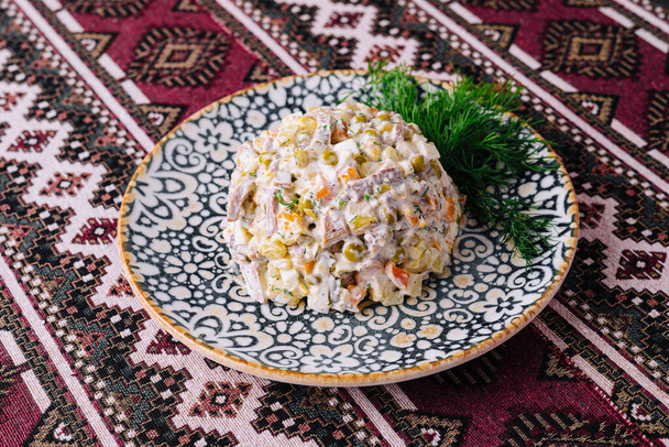 Salade Olivier servie dans une assiette décorative, un plat classique pour les fêtes - Photo, image