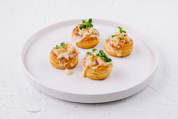 Tres deliciosos camarones vol-au-vents adornados con hierbas en un plato blanco, perfecto para aperitivos elegantes - Foto, imagen