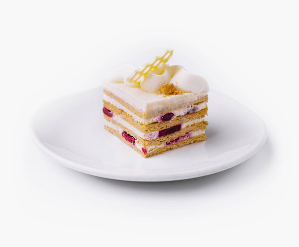 Gourmet gelaagde taart met room en fruit vulling op een ongerepte witte achtergrond - Foto, afbeelding