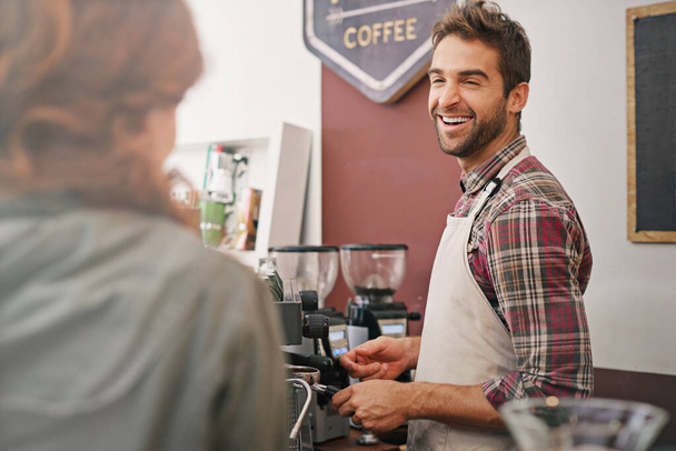 Happy man, waiter and woman in coffee shop at counter with machine for order, service and catering. Barista, client or person in cafe for drink, tea or espresso with smile, chat or helping in Italy. - Photo, Image
