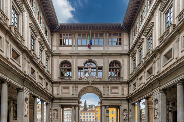 Галерея Уффици во Флоренции вид на внутренний двор с аркадами с колоннами и арками и статуями - Фото, изображение