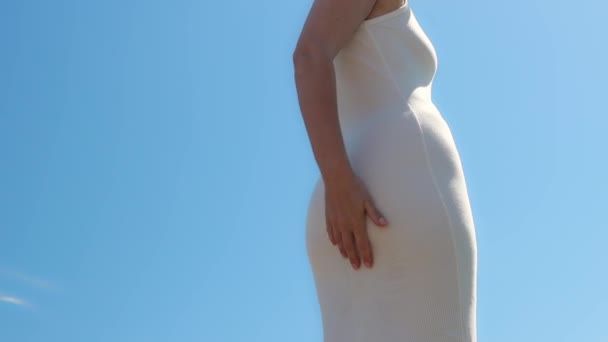 νεαρή γυναίκα με λευκό φόρεμα στην παραλία - Πλάνα, βίντεο