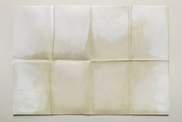 Empty sheet folded in eight, old paper isolated on gray background - Photo, Image