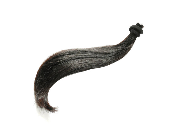 eine Strähne natürliches schwarzes Haar befestigt mit einem Haarband isoliert auf weißem Hintergrund - Foto, Bild