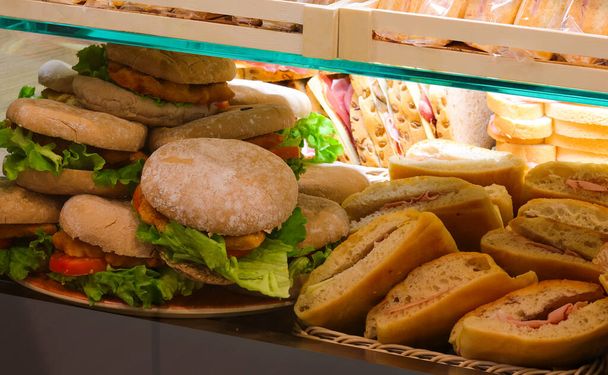 broodjes met vleeswaren en groenten te koop voor een snelle middagpauze - Foto, afbeelding
