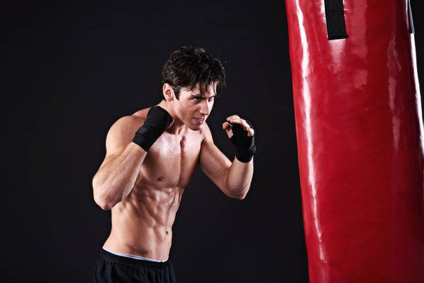 Человек, боксерская груша и боевые искусства с упражнениями, тренировки и боец с перчатками и оздоровление с силой. Боксер, практика и спортсмен с фитнесом и тренировкой с выносливостью, здоровой и прогрессивной. - Фото, изображение