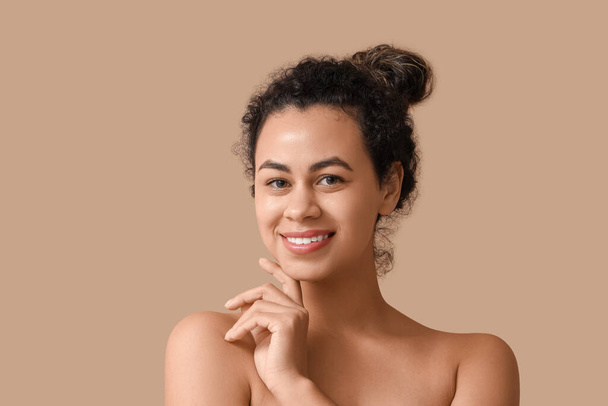 Gyönyörű fiatal afro-amerikai nő barna háttér - Fotó, kép