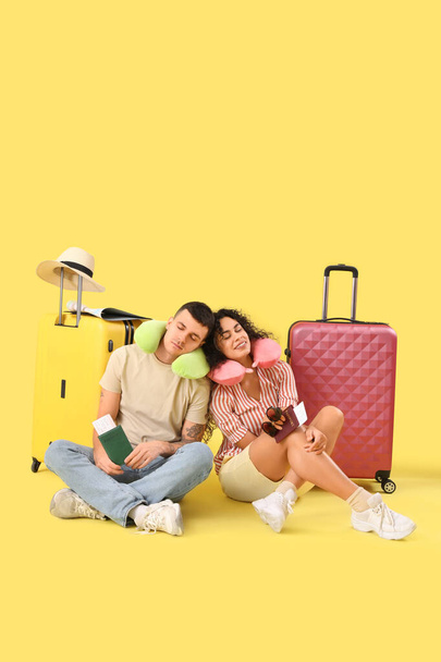Couple of tourists with suitcases and passports on yellow background - Photo, Image