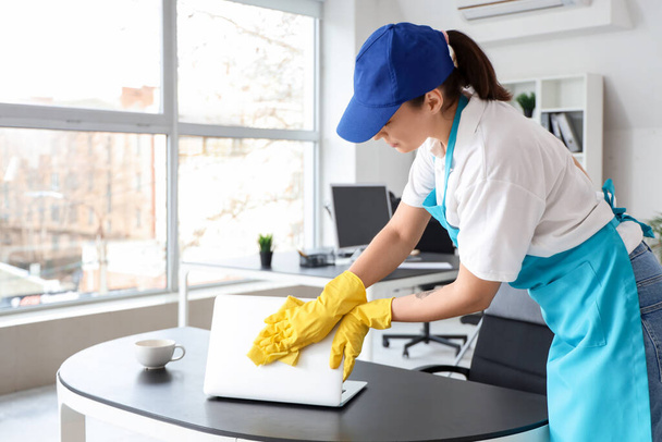 Female janitor cleaning table in office - Photo, Image
