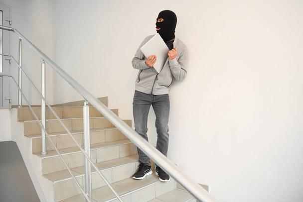 Ladro maschio con laptop in fuga nelle scale - Foto, immagini