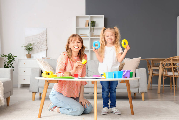 Nanny and little girl playing with toys on table at home - Φωτογραφία, εικόνα