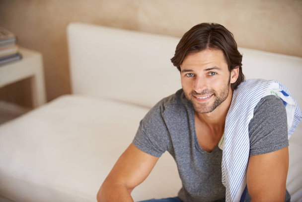 Portrait, man or smile to relax in fashion, apparel or casual outfit on sofa in lounge in Turkey. Male designer, happy or couch as look, rest or satisfaction of stylish comfortable weekend break. - Photo, Image