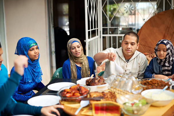 Familia, musulmán y casa en la cena para eid o ramadán en la mesa para la religión para disfrutar y satisfecho. Fe, Islam y fiesta en la cena de ayuno en traje religioso para la comida y la unión entre sí. - Foto, Imagen