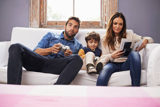 Family, controller or video game to relax, technology or sofa on metaverse, esports or bonding. Man, mama or child on couch, remote or gaming as excited, virtual or competition or play console. - Photo, image