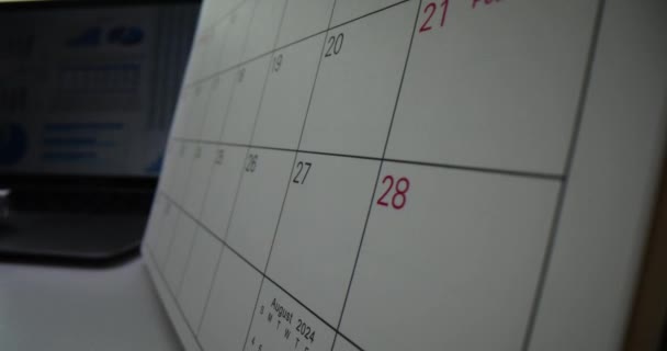 Przewijam miesięczny kalendarz w ciemnym biurze. Planowanie i harmonogram tygodnia miesiąca - Materiał filmowy, wideo