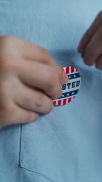 Großaufnahme eines anonymen Geschäftsmannes oder Mannes, der ein Abzeichen mit dem Logo der amerikanischen Flagge und der Aufschrift I Voting trägt. US-Bürger während der Wahlen im Wahllokal. Nationaler Wahltag in den Vereinigten Staaten. - Filmmaterial, Video