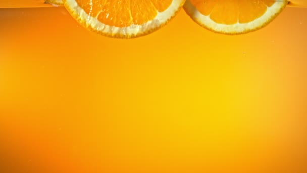Super Slow Motion Shot de rodajas de naranja fresca cayendo y fluyendo en el agua a 1000 fps. Filmado con cámara de cine de alta velocidad en resolución 4K. - Imágenes, Vídeo