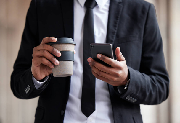 Businessman, closeup and phone with coffee or typing for email, communication with technology for company. Male person, hands and espresso or mobile and check for schedule, reminder for work on app. - Photo, Image