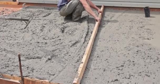 Lavori in calcestruzzo muratore utilizza strumenti speciali per livellare malta fondazione cemento. - Filmati, video