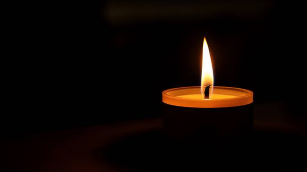 Una vela solitaria ardiendo en la oscuridad. - Foto, Imagen
