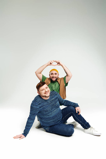 Zwei Männer sitzen zusammen und posieren für ein Foto. - Foto, Bild