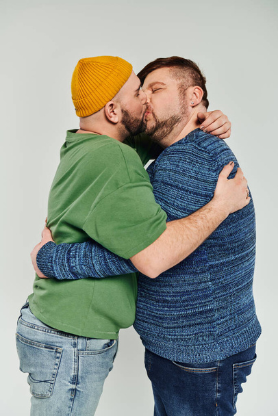 Kaksi miestä suutelee rakastavasti valkoisella taustalla. - Valokuva, kuva
