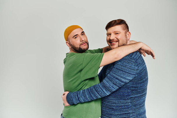 Twee mannen knuffelen warm voor een witte achtergrond. - Foto, afbeelding