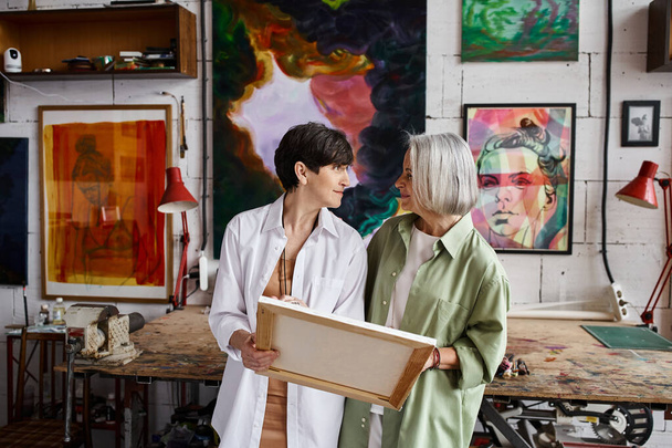 Two mature lesbian women standing in an art studio. - Photo, Image