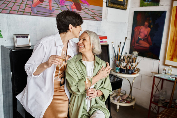 Δύο γυναίκες κάθονται μαζί σε ένα στούντιο τέχνης.. - Φωτογραφία, εικόνα