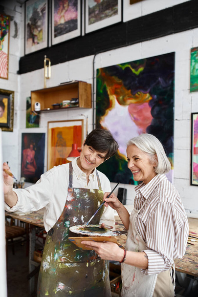Δύο γυναίκες ζωγραφίζουν σε ένα στούντιο τέχνης μαζί.. - Φωτογραφία, εικόνα