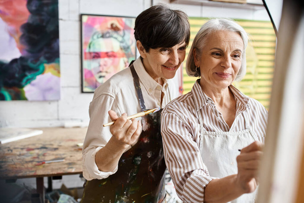 Δύο γυναίκες ζωγραφίζουν μαζί σε ένα στούντιο τέχνης.. - Φωτογραφία, εικόνα