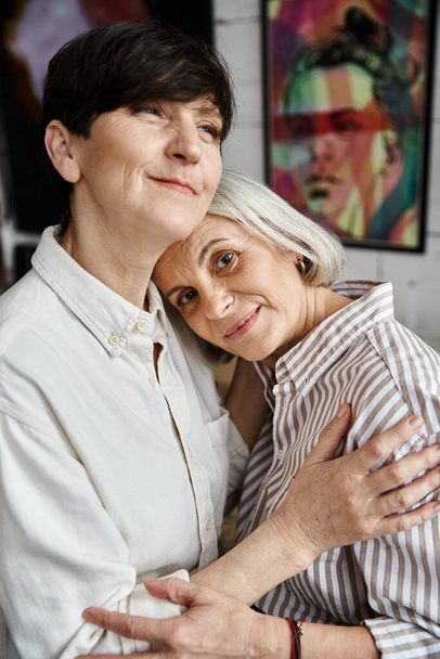 Két nő élénk festmények előtt.. - Fotó, kép