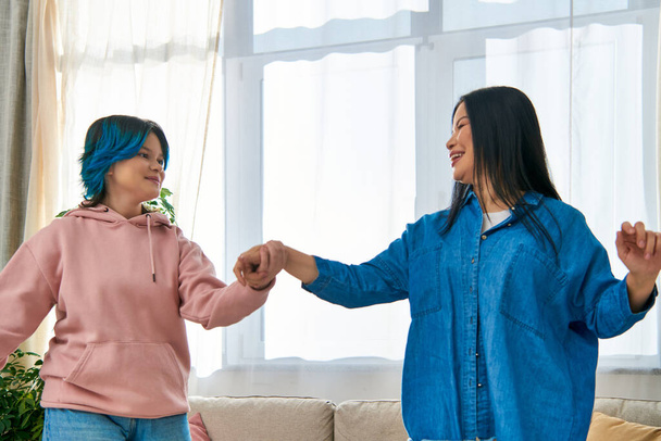 Een Aziatische moeder en haar tienerdochter staan nauw naast elkaar in casual kleding, het delen van een moment van verbinding. - Foto, afbeelding