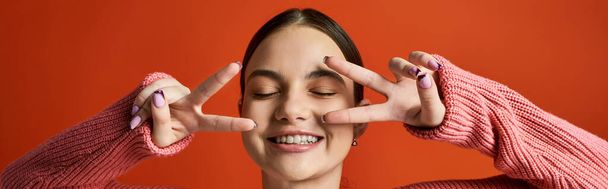 Una ragazza adolescente bruna in abbigliamento casual tiene le mani davanti ai suoi occhi, creando un effetto simile a un velo. - Foto, immagini