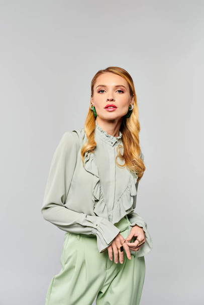 Chic woman wearing a green blouse and wide leg pants poses elegantly. - Photo, Image