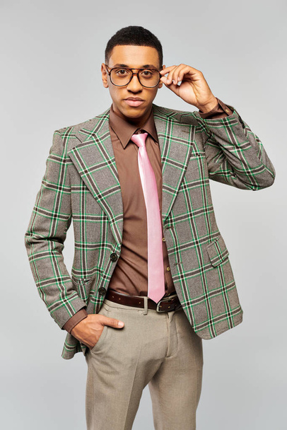Un hombre de moda posa con confianza en una elegante chaqueta a cuadros. - Foto, Imagen