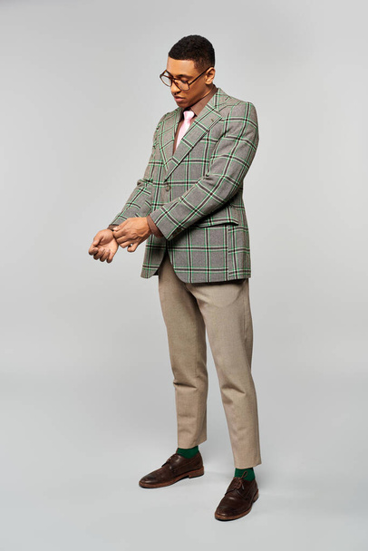A fashionable man in a plaid blazer posing confidently for the camera. - Photo, Image