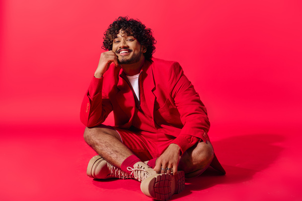 Handsome young Indian man in red suit sitting gracefully. - Photo, Image